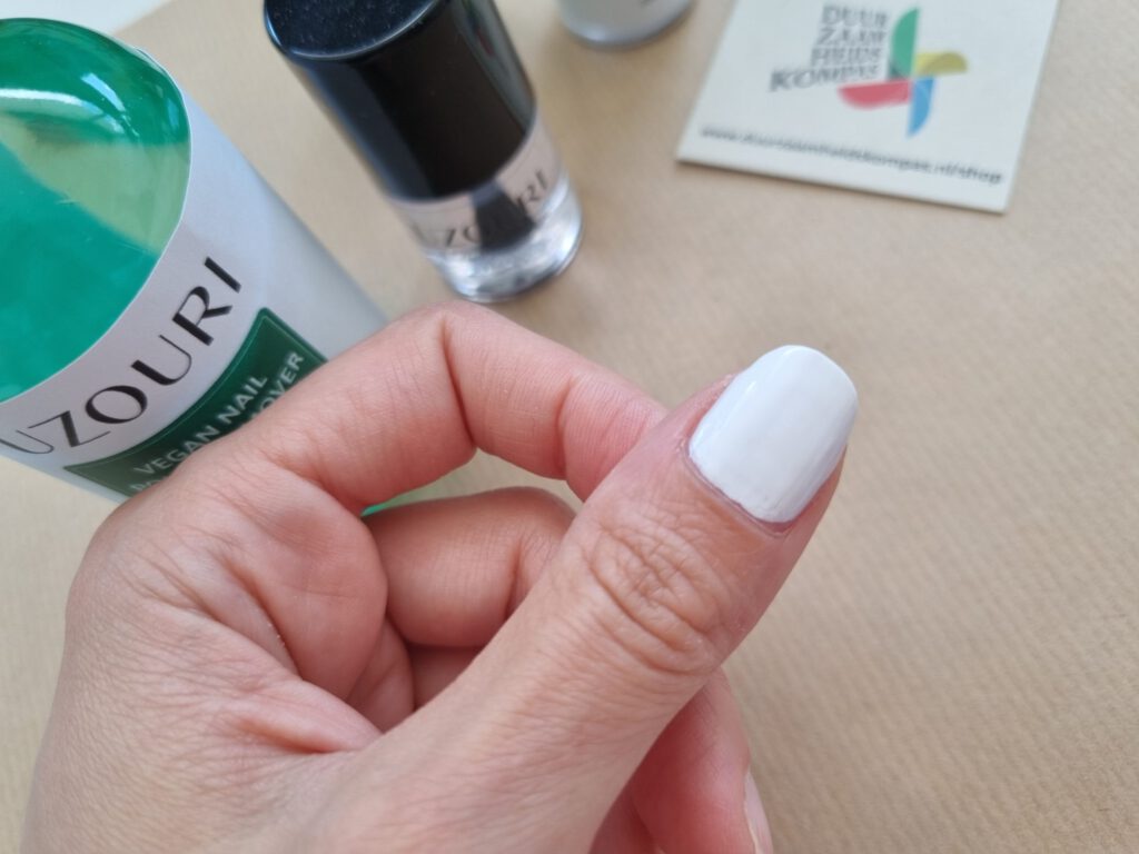 duim met witte vegan nagellak